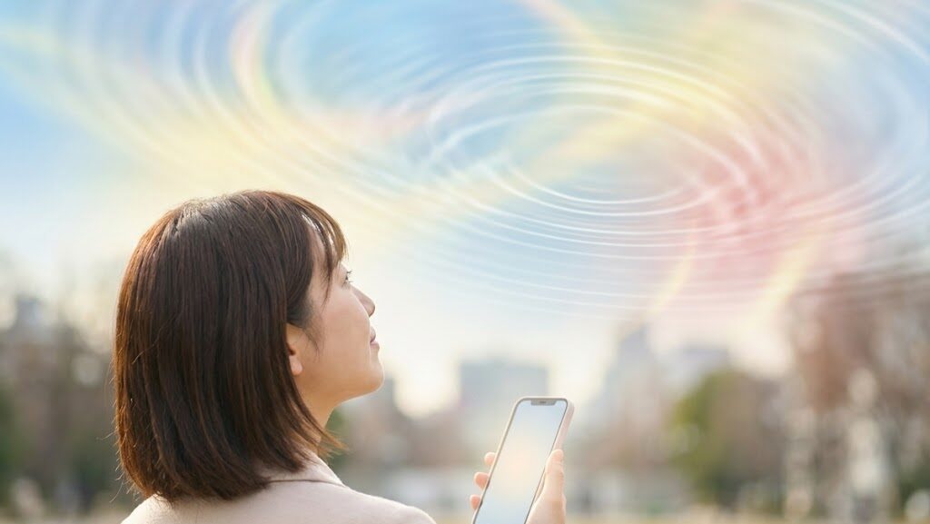 屋外でスマホの位置情報を確認する日本人と、GPSの乱れを示す光の抽象表現の画像