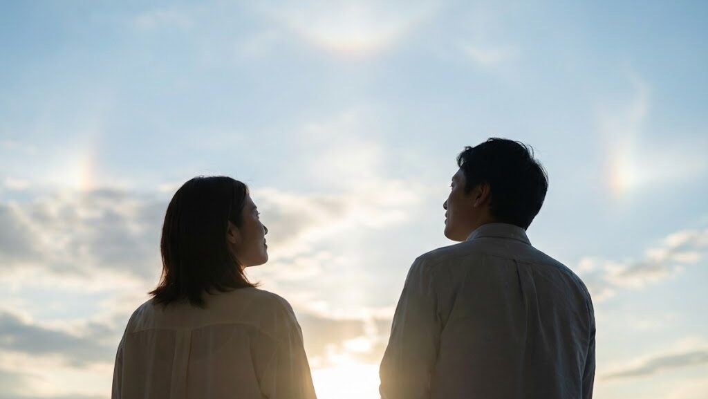 日本人が空を見上げ、太陽を観察している穏やかな実写風の生活シーン