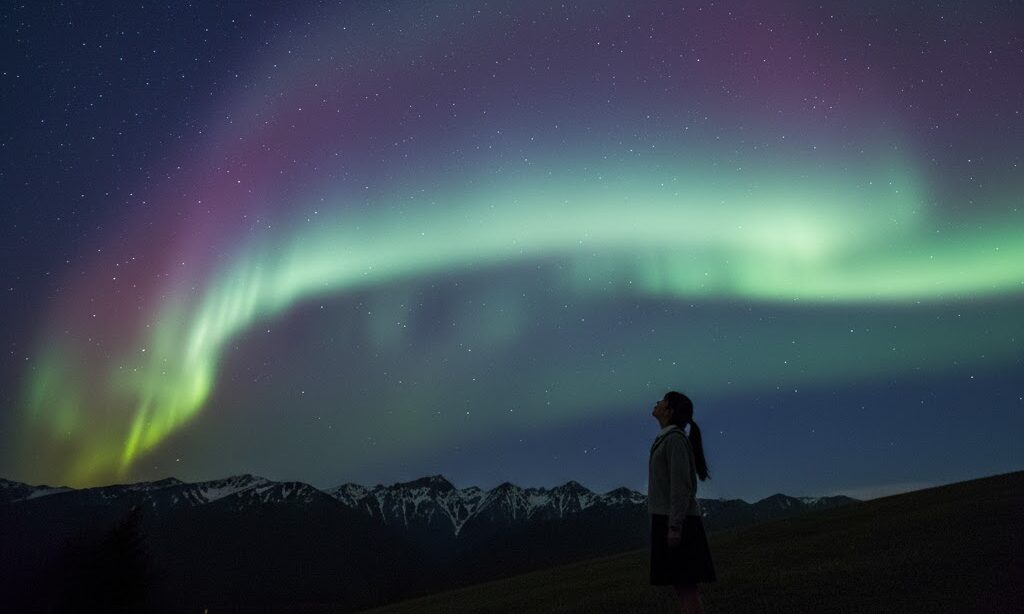 オーロラがなぜできるかを見上げる日本人中学生と夜空の光