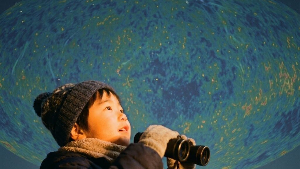 双眼鏡で夜空を見る子どもと、背景に淡く浮かぶ抽象的なマイクロ波模様のイメージ。