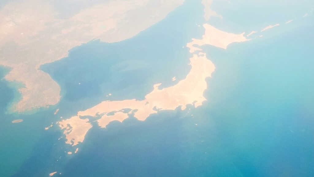 海上から見た日本列島の抽象的な光のシルエット。南海トラフ地震の発生時期を考えるイメージ