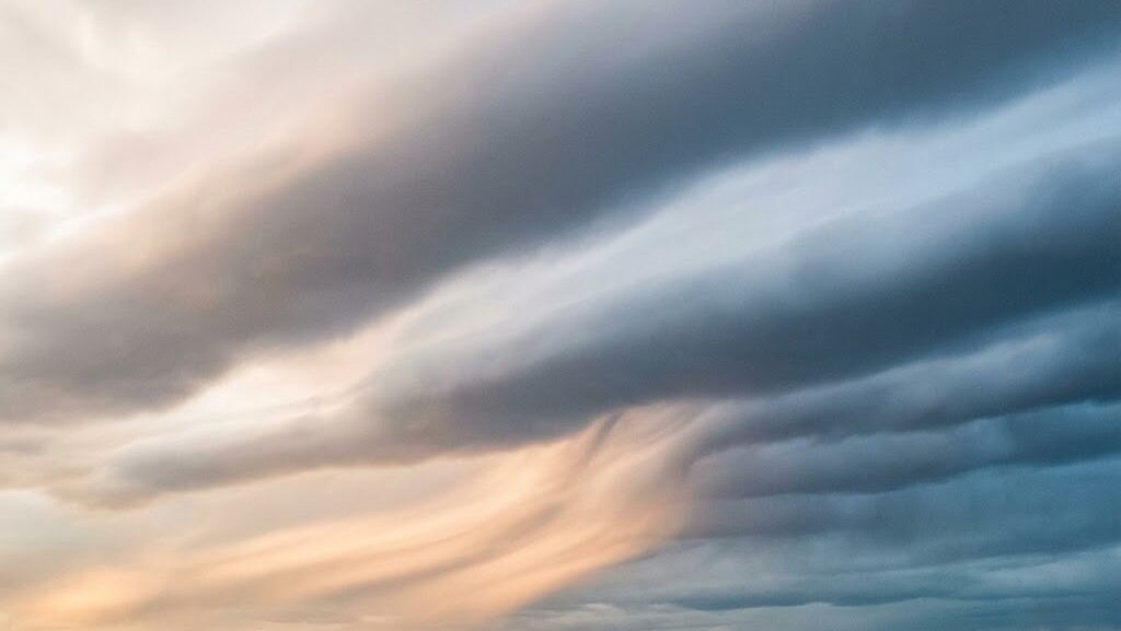 線状降水帯が増えた理由を示す帯状の雲の実写風イメージ