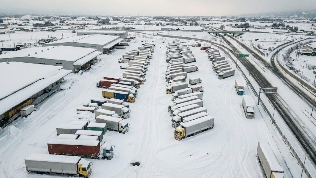 大雪によって物流や交通が停滞した日本の幹線道路周辺の風景