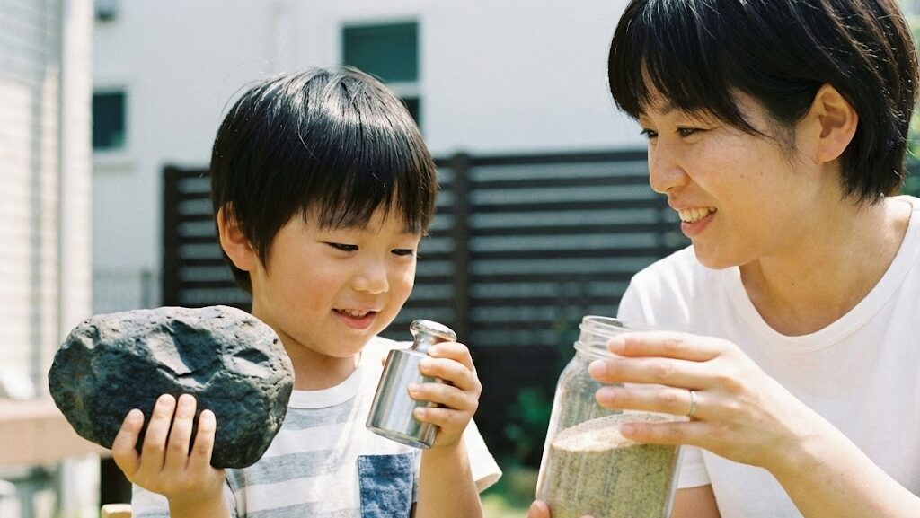石や金属の重さを比べながら、地球内部が重い物質でできている理由を考えている様子