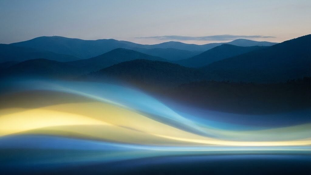 「山並みの下に静かに収束する光の層。地震活動が弱まる“静穏化”を抽象的に表現したイメージ」