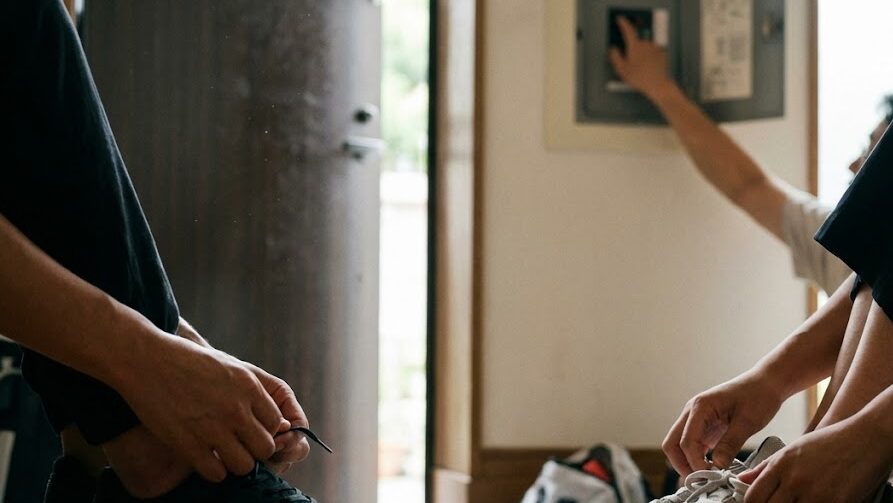 避難前にブレーカーを切る重要性を伝えるための日本の住宅玄関と分電盤の様子