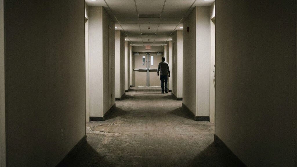 火災時の避難を意識し非常階段へ続く通路を確認する重要性を示す建物内の風景