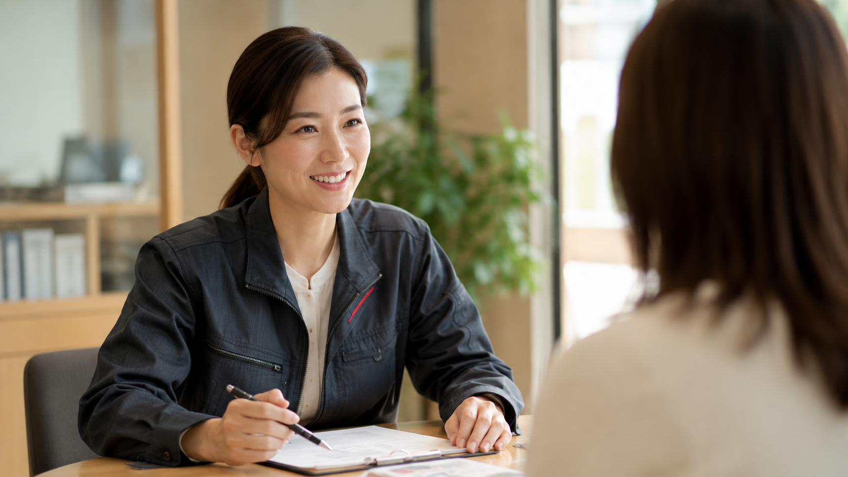 防災相談に対応するHIHスタッフの女性が、オフィスでお客様の問い合わせを丁寧に聞く様子