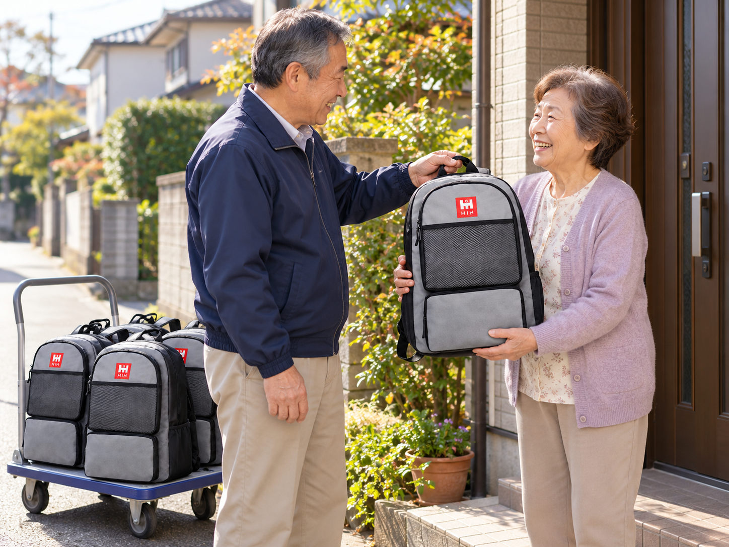 町内会の役員さんが、各家庭の玄関先で防災リュックを手渡している様子